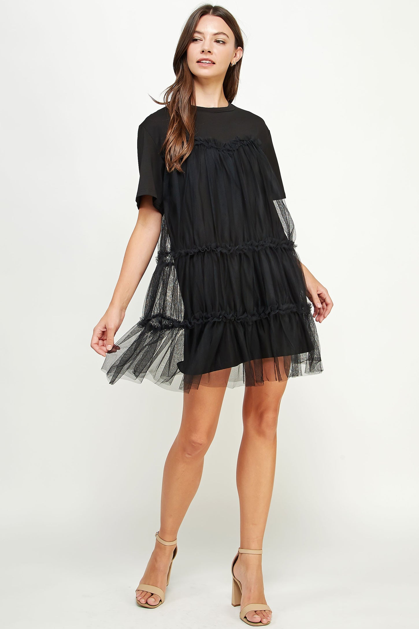 woman wearing a black tiered tulle dress with short sleeves and a relaxed fit