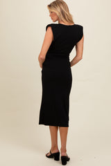 woman wearing a black sleeveless maternity dress, showing a fitted silhouette and mid-calf length from the back