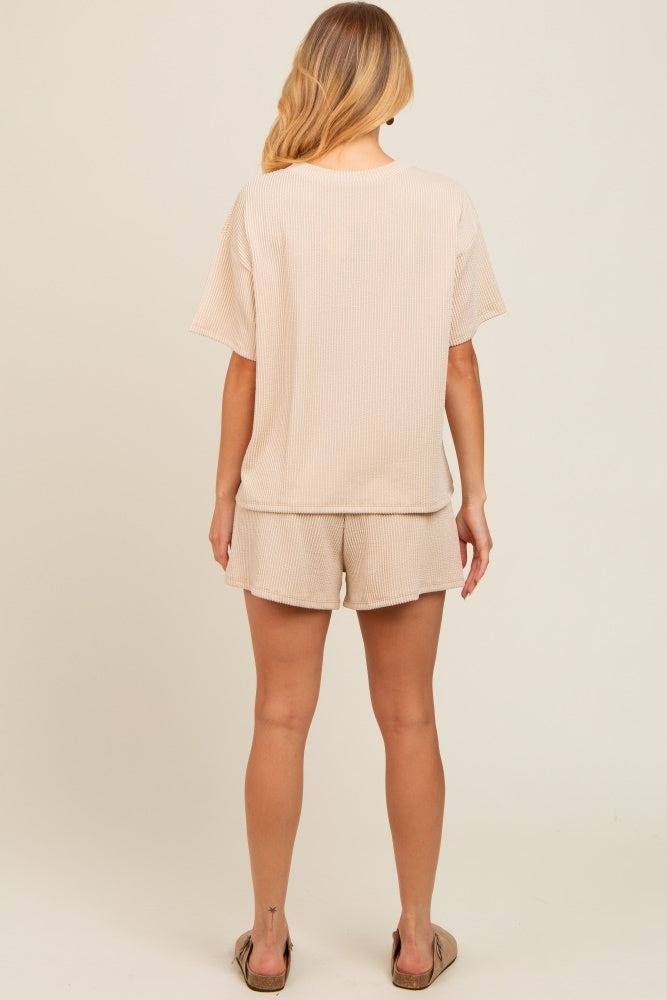 woman wearing a beige ribbed short sleeve top and matching shorts, viewed from the back
