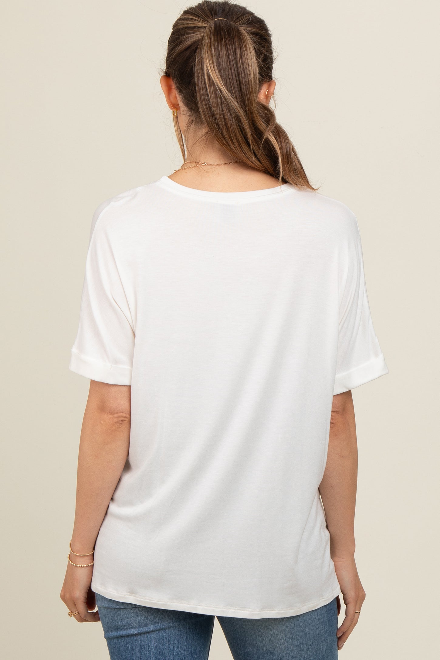 woman wearing a white short sleeve maternity top viewed from the back
