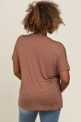 woman wearing a brown short sleeve top with rolled cuffs, showing the back view and styled with blue jeans