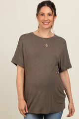 woman wearing a dark olive green short sleeve maternity top and showing her baby bump