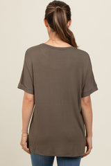 woman wearing a loose-fitting olive green maternity top, viewed from the back, with rolled sleeves and a relaxed silhouette
