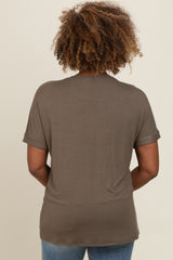 woman wearing a back view of a short sleeve olive green top with rolled sleeves and casual fit