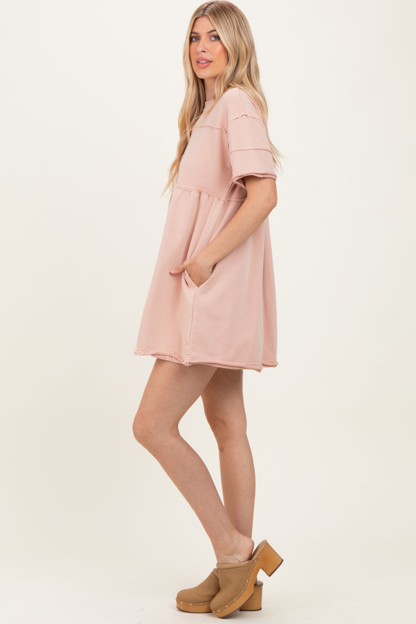woman wearing a light pink short sleeve oversized dress with pockets and a relaxed fit