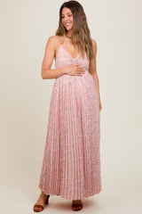 woman wearing a light pink floral maternity maxi dress with pleated detailing and a v-neckline