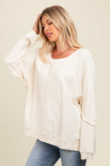 woman wearing a cream oversized pullover sweater with textured detailing and relaxed fit