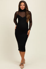 woman wearing a black maternity dress with a fitted design and sheer long sleeves, displaying a baby bump