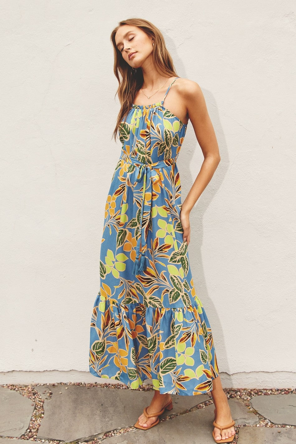 woman wearing a blue floral maxi dress with spaghetti straps and a tie waist detail