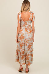 woman wearing a floral print maternity maxi dress with smocked bodice and tie shoulder straps