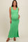 woman wearing a green ribbed maternity maxi dress with a side slit and holding her baby bump