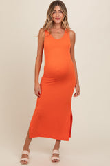 woman wearing an orange ribbed maternity maxi dress with a side slit and showing her baby bump
