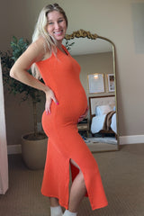 woman wearing an orange ribbed maternity dress with side slits and holding her baby bump