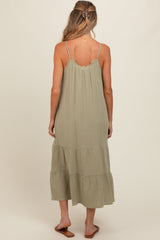 woman wearing a light green tiered maternity dress with thin straps, showing the back view