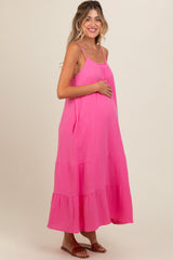 woman wearing a hot pink maternity dress with tiered layers and a visible baby bump