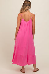 woman wearing a pink maternity maxi dress with tiered layers and thin straps, showing her baby bump from the back