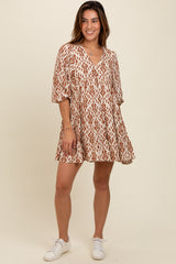 woman wearing a cream and rust patterned short dress with a v-neckline and puff sleeves