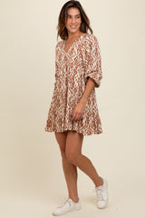 woman wearing a brown and cream patterned short dress with three-quarter sleeves and a v-neckline