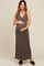 woman wearing a brown maternity maxi dress with a tie front and holding her baby bump