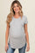 woman wearing a light gray maternity t-shirt with a curved hem and visible baby bump, paired with blue jeans
