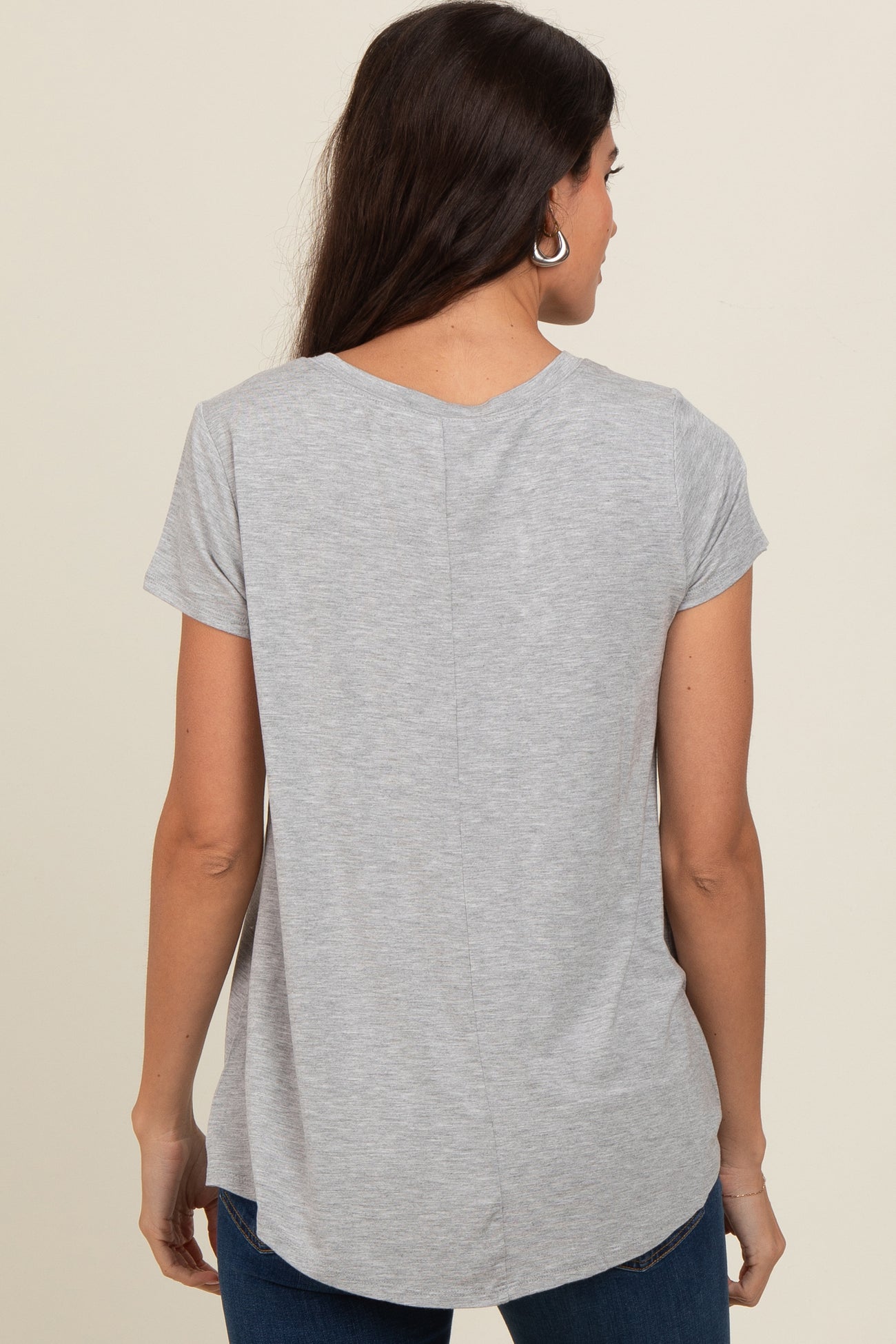 woman wearing a gray short sleeve top with a curved hem and back seam detail