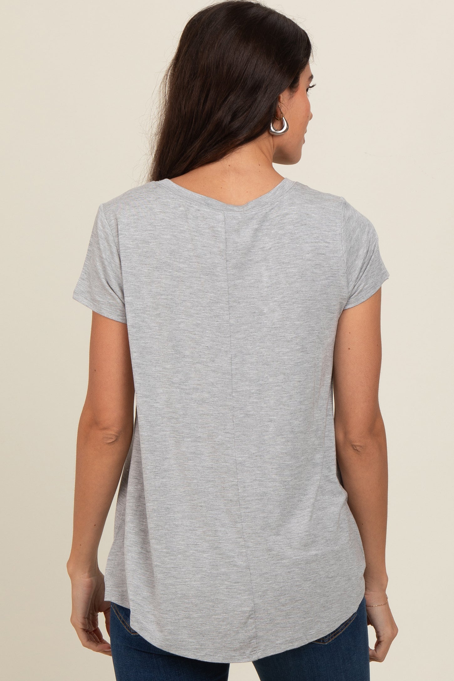 woman wearing a gray short sleeve top with a curved hem and back seam detail