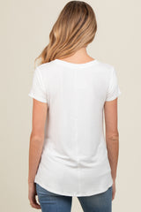 woman wearing a white short sleeve maternity top, viewed from the back, paired with blue jeans