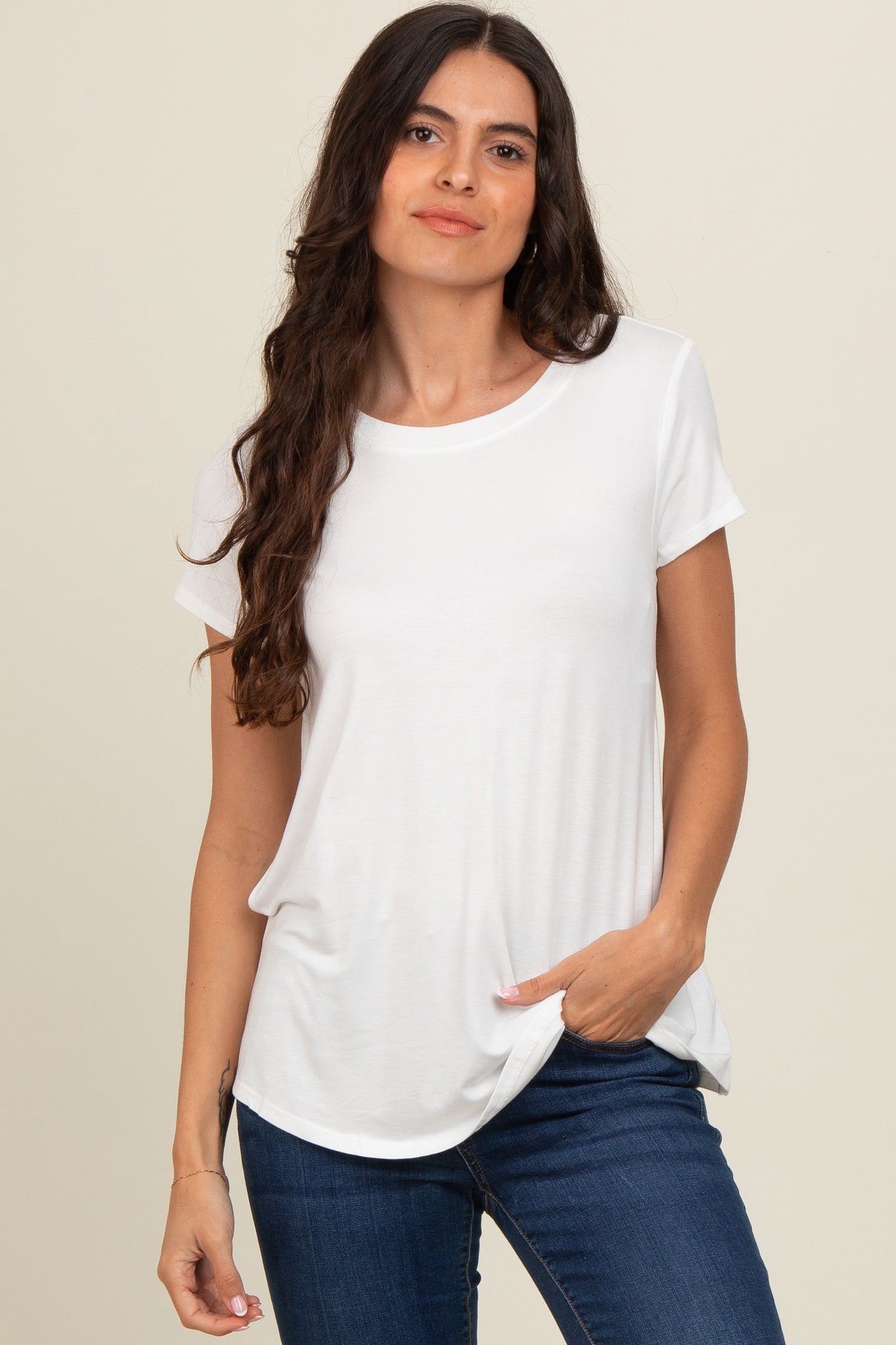 woman wearing a white short sleeve t-shirt with a relaxed fit and a pocket, paired with blue jeans