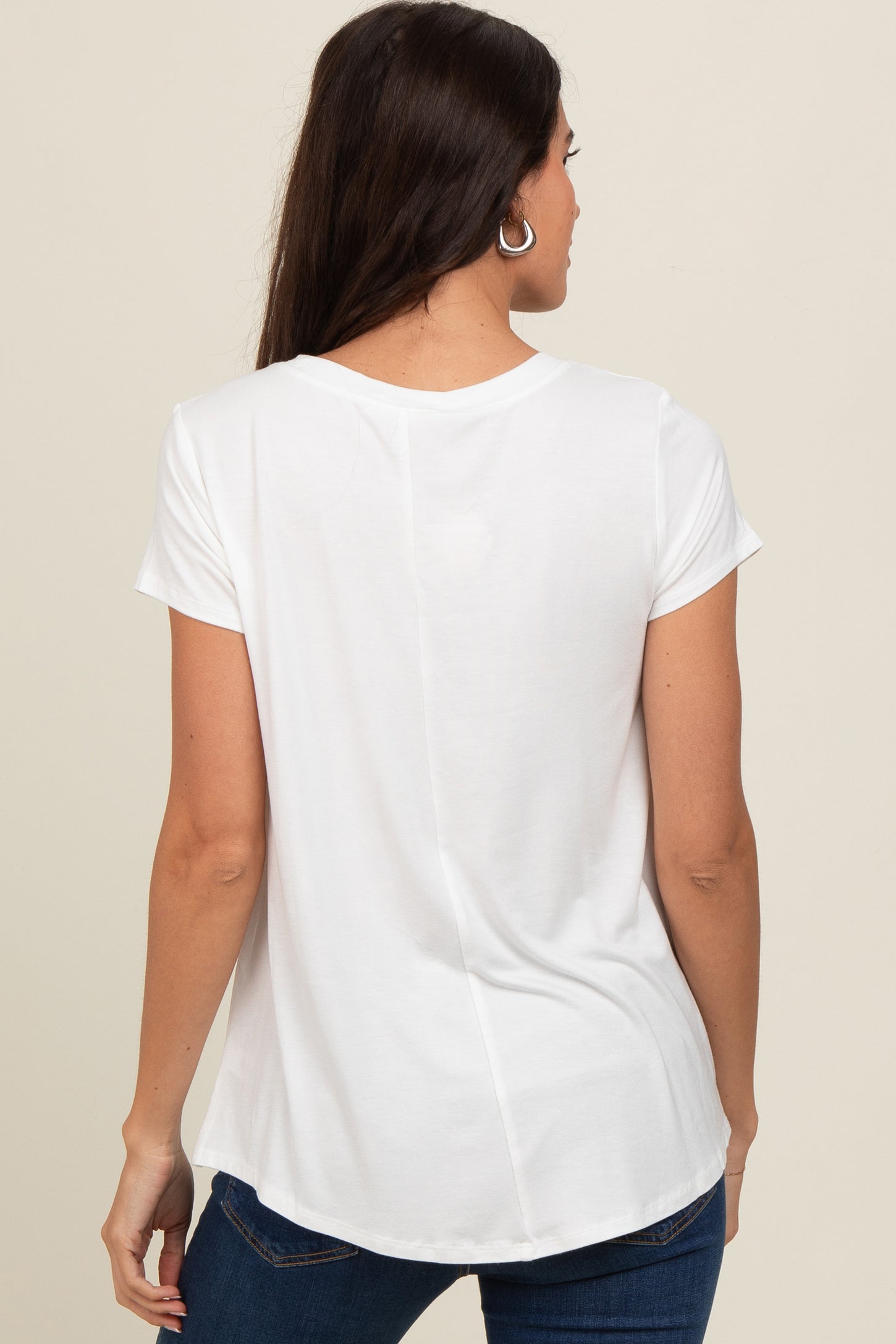 woman wearing a white short sleeve top with a rounded hem and back seam detail, seen from the back