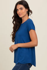 woman wearing a blue short sleeve top with a relaxed fit and side slits, paired with jeans