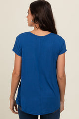 woman wearing a blue short sleeve casual top, showing a relaxed fit and rounded hem from the back