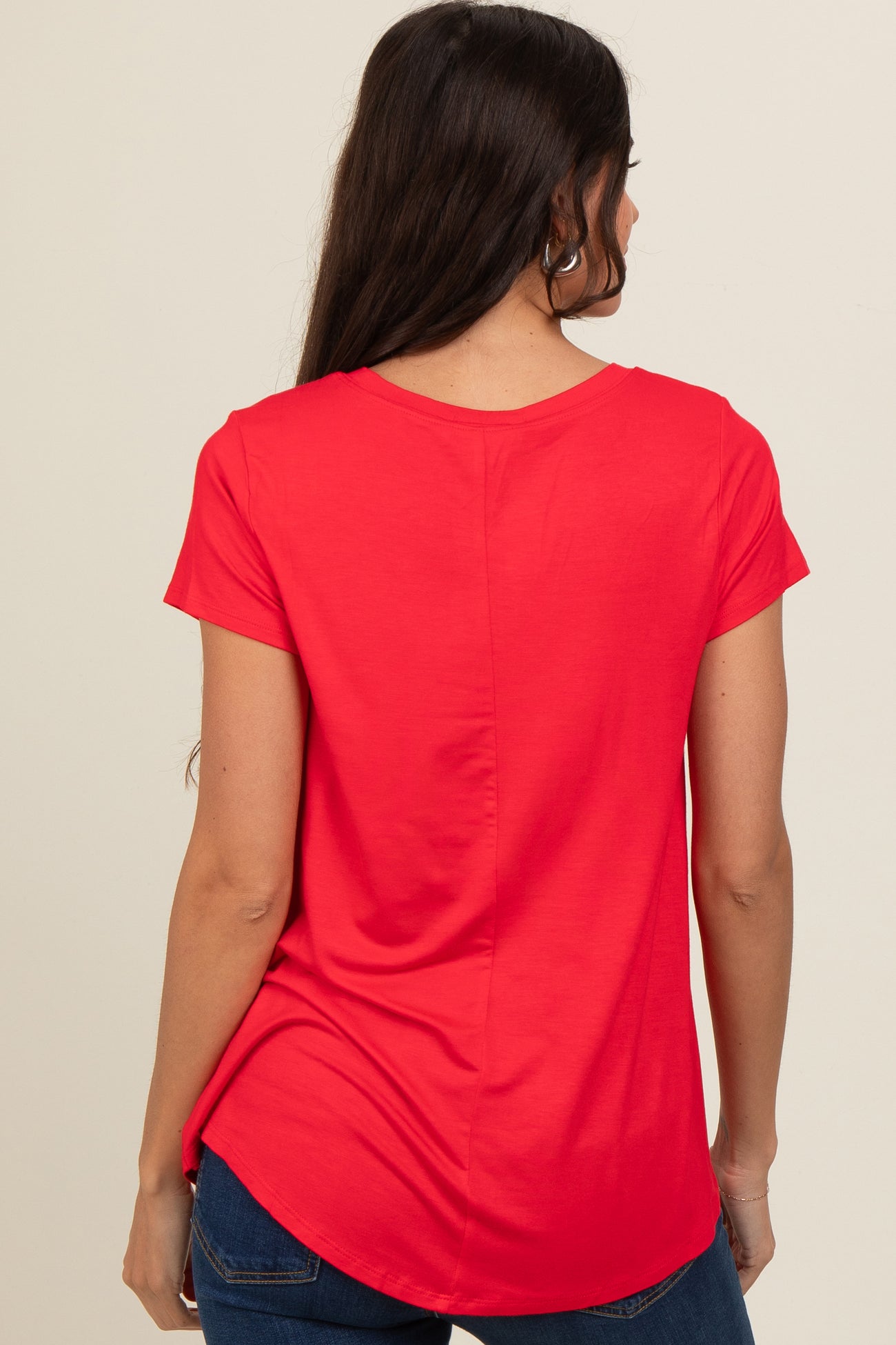 woman wearing a red short sleeve top with a rounded hem and a slightly longer back view