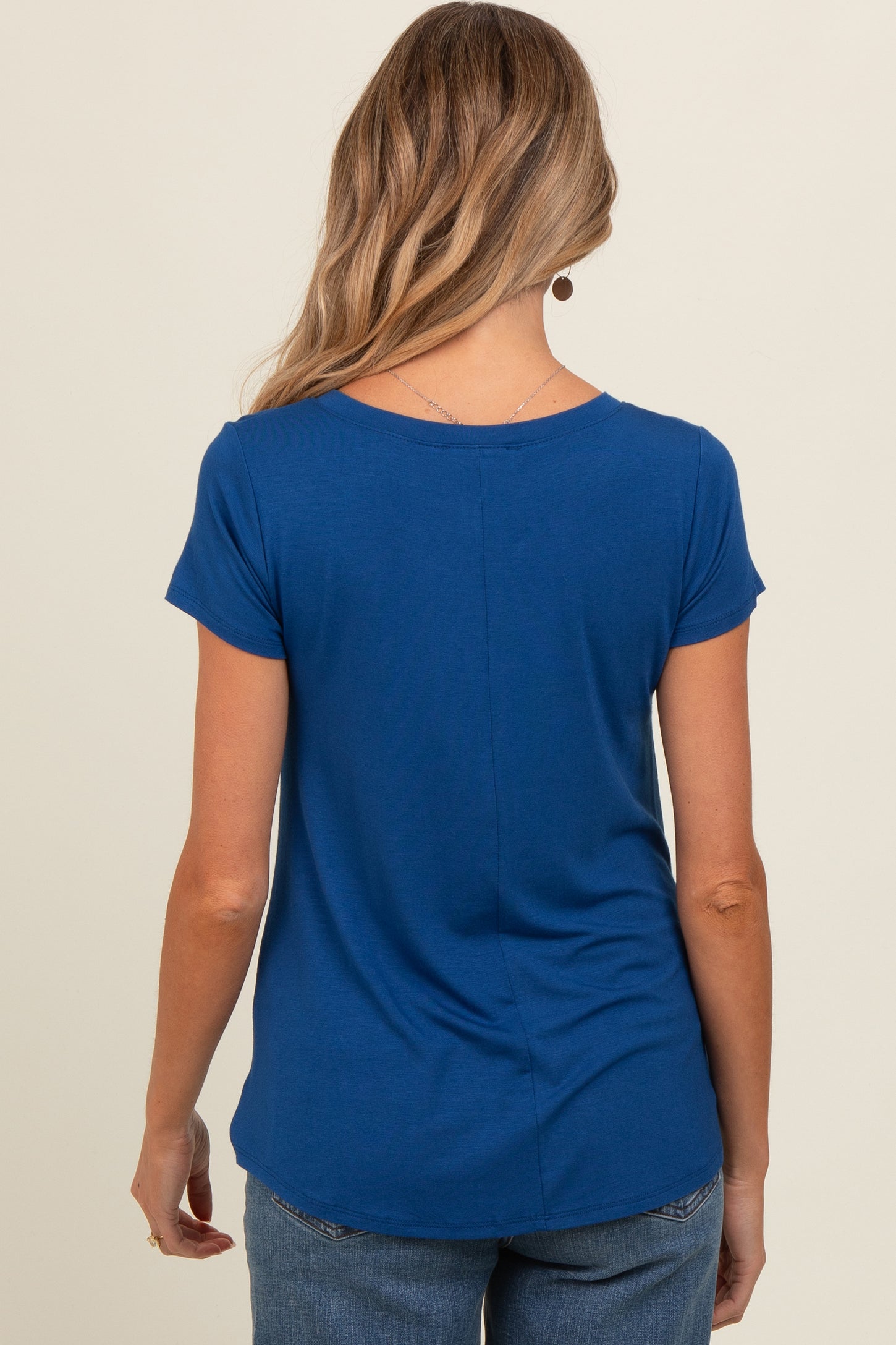 woman wearing a navy blue maternity top, shown from the back, with short sleeves and a relaxed fit