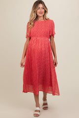 woman wearing a red floral maternity dress with short sleeves and a pleated skirt, showing her baby bump