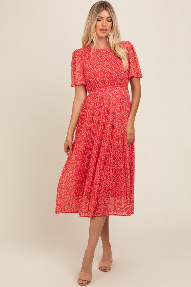 woman wearing a red floral midi dress with short sleeves and a pleated skirt