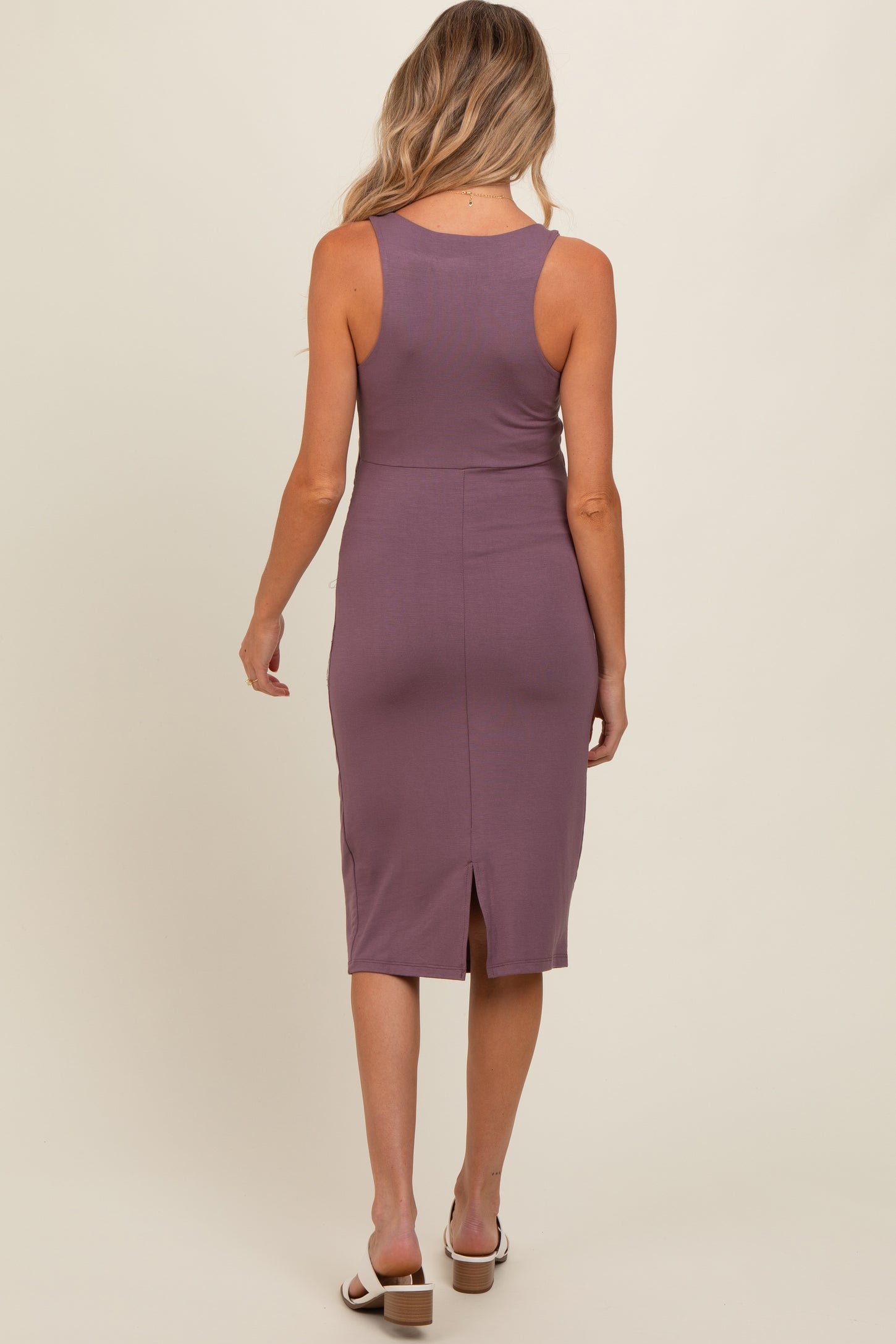woman wearing a purple maternity dress with a fitted style and a back slit detail