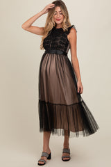 woman wearing a black maternity dress with lace bodice and tulle skirt, showcasing her baby bump