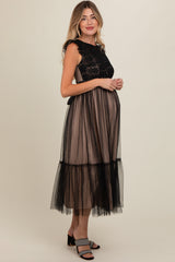 woman wearing a black lace and tulle maternity dress with a baby bump visible