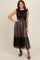 woman wearing a black lace and tulle maxi dress with a fitted bodice and tiered skirt