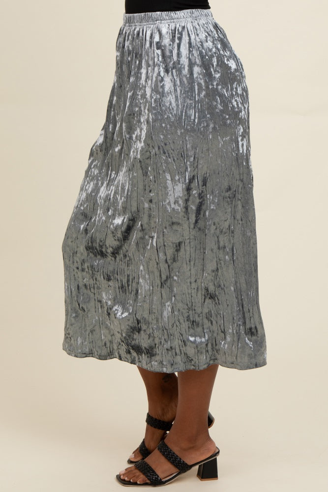 woman wearing a shiny silver pleated midi skirt and black strappy heels