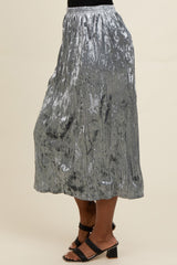 woman wearing a shiny silver pleated midi skirt and black strappy heels