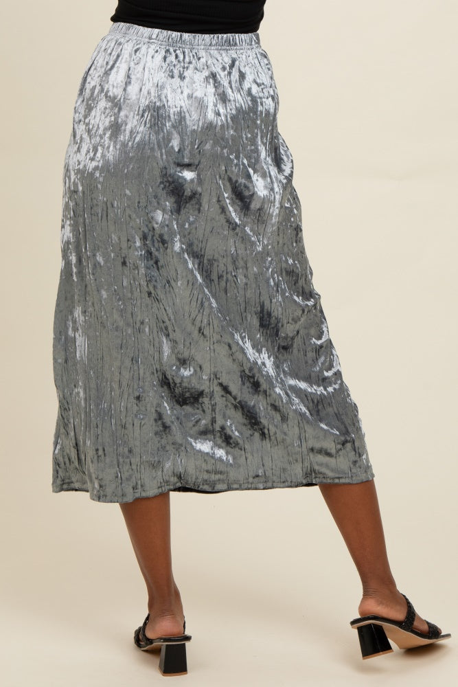 woman wearing a silver pleated midi skirt with an elastic waistband and strappy black sandals
