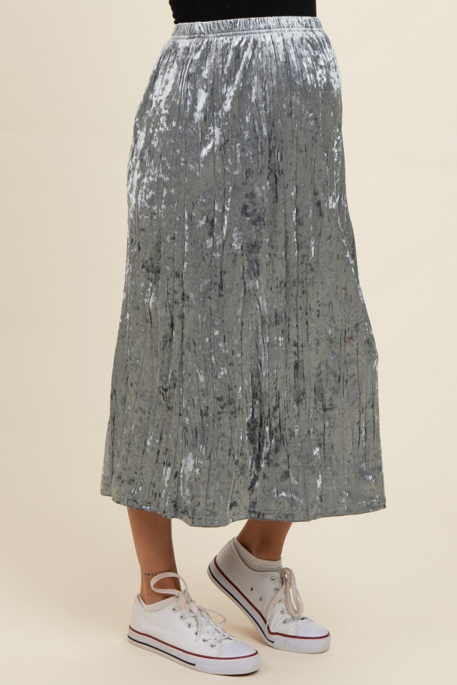 woman wearing a silver velvet maternity skirt with pleats and sneakers, showcasing a baby bump