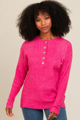 woman wearing a bright pink ribbed sweater with a button placket and long sleeves