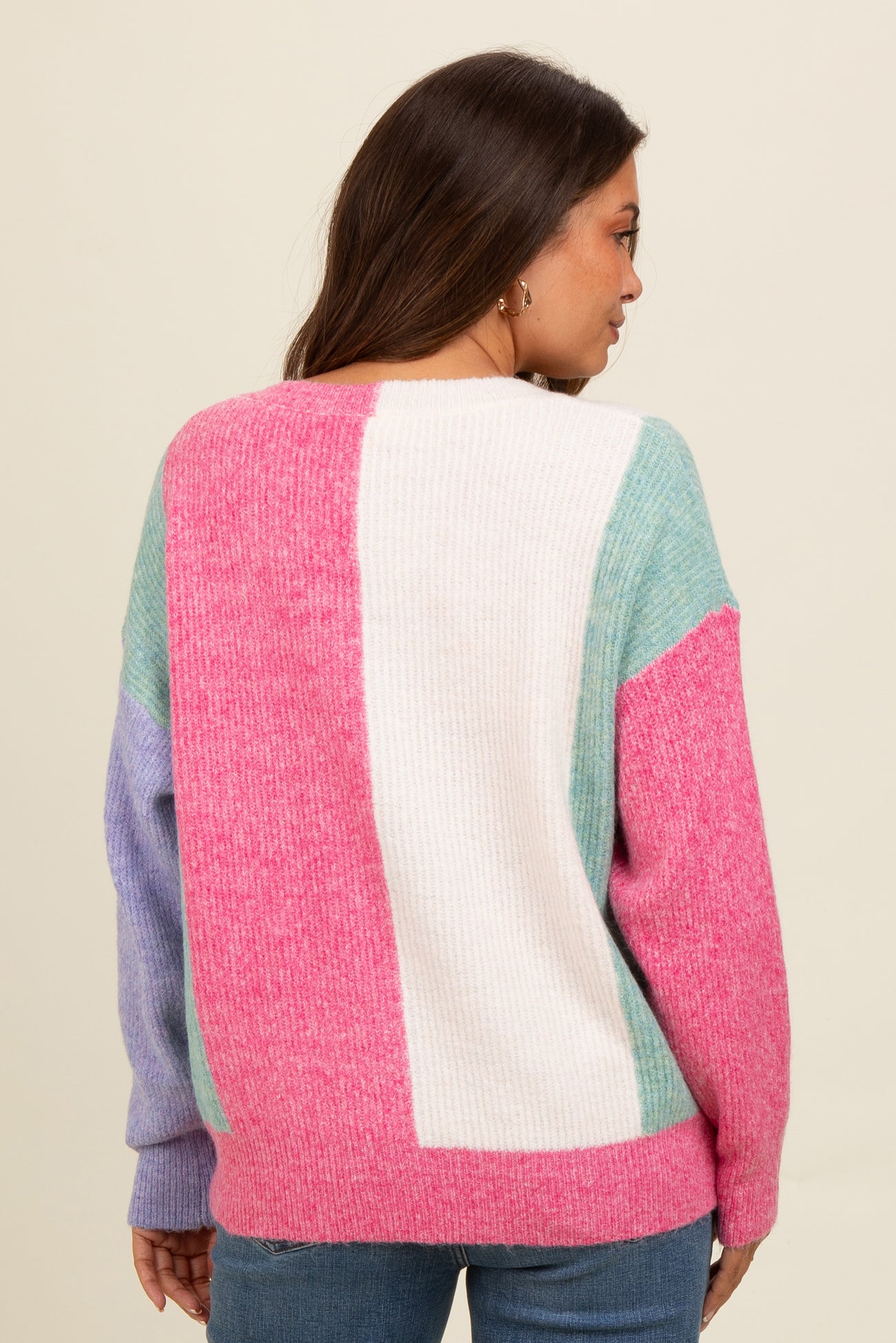 woman wearing a color block maternity sweater in pink, mint, and lavender, showing a relaxed fit and back view