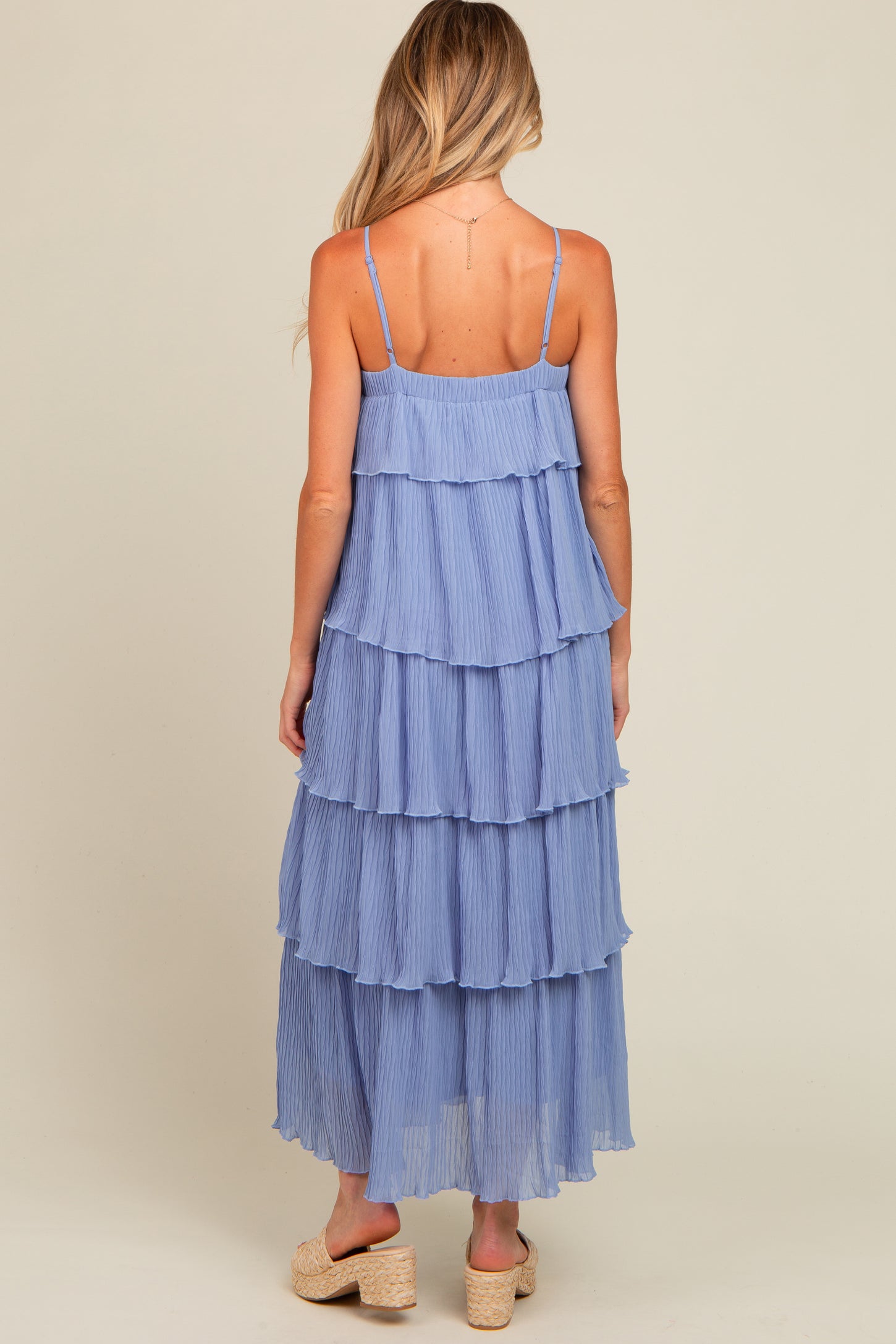 woman wearing a light blue tiered maternity maxi dress with adjustable spaghetti straps and a flowy design
