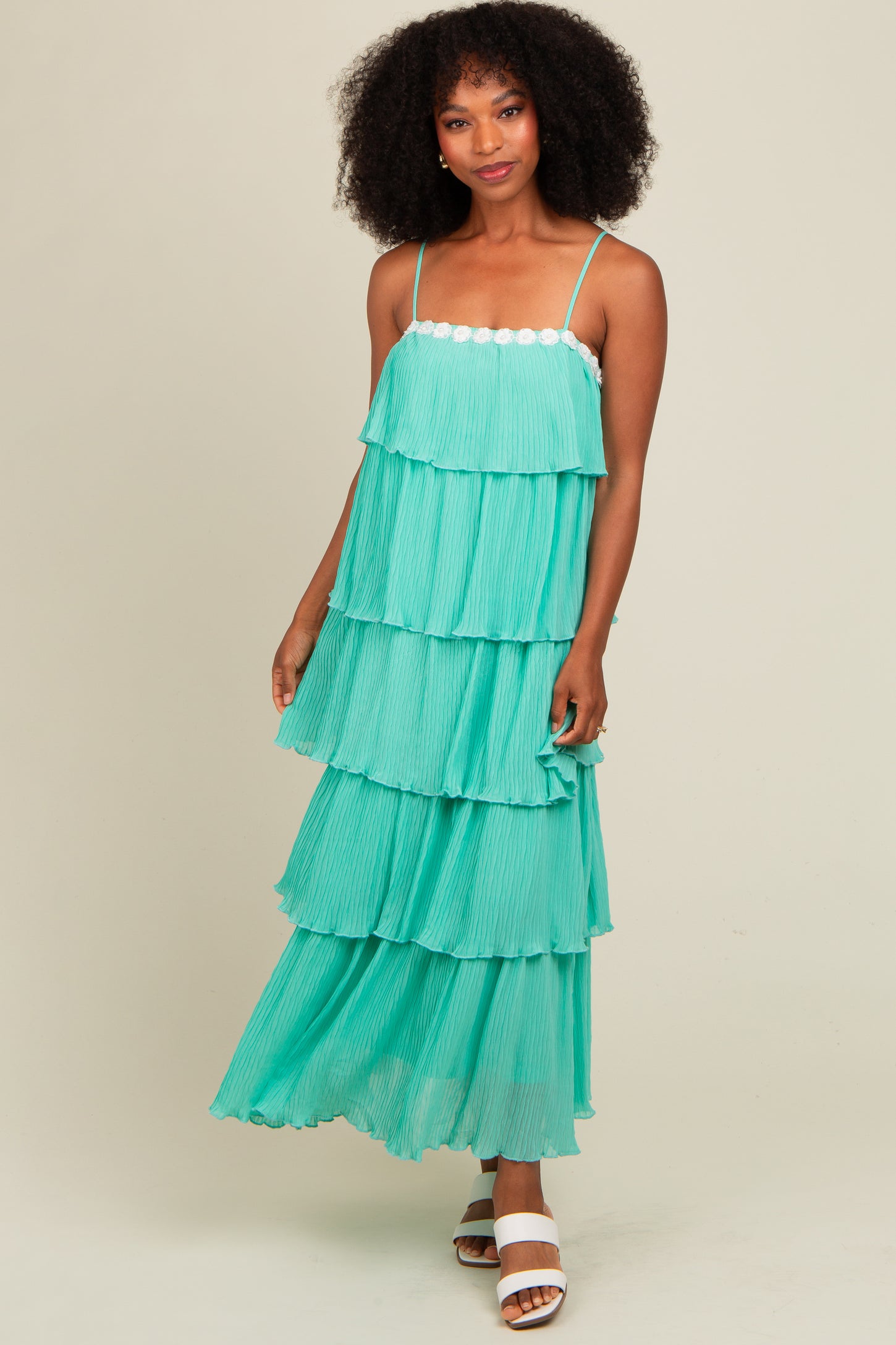 woman wearing a teal tiered maxi dress with spaghetti straps and ruffled layers