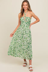 woman wearing a green floral halter neck maxi dress with a keyhole cutout and tiered skirt