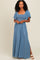 woman wearing a light blue smocked maxi dress with short sleeves and a side slit