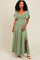 woman wearing a green maxi dress with smocked bodice and flutter sleeves, featuring a thigh-high slit